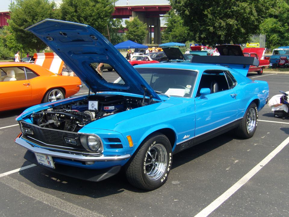 Blue 1970 Ford Mustang Mach 1 with hood open, parked next to an orange car