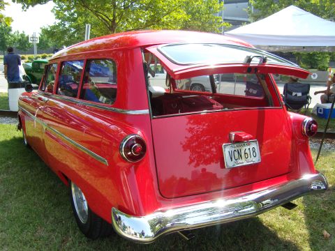2007 Ford Mustang - 1955 Ford station wagon with its tailgate open, parked on grass.