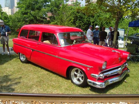 2007 Ford Mustang - A bright red vintage station wagon is displayed outdoors on a sunny day.