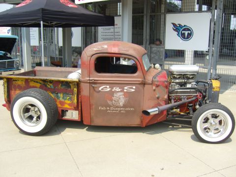 2007 Ford Mustang - This custom rat rod pickup truck features an exposed engine and a prominent G&S Fab & Suspension logo on its side.