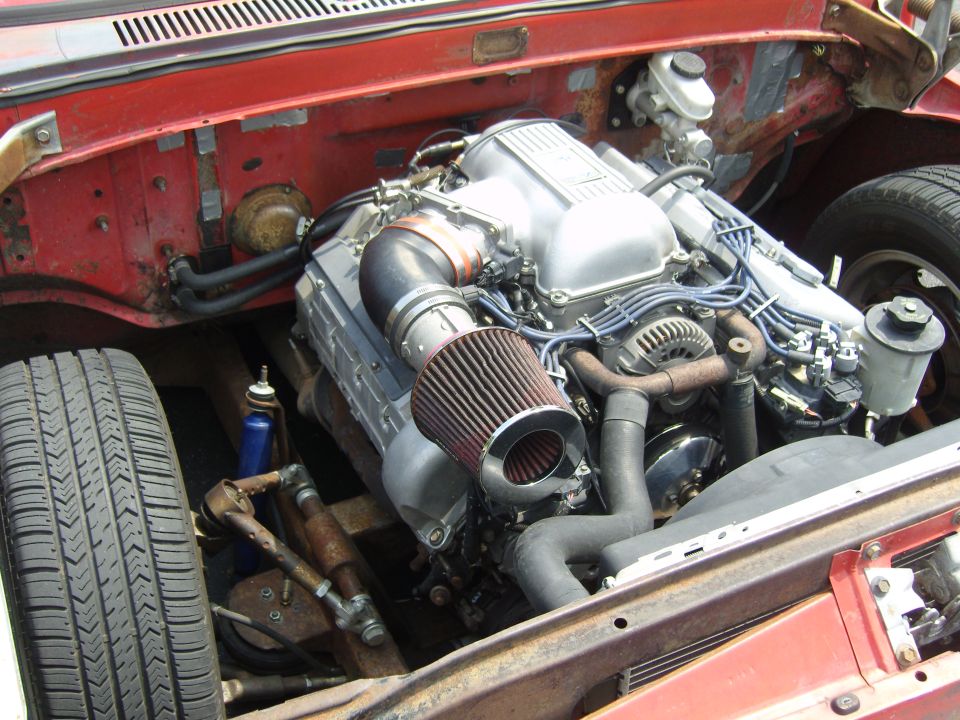 Engine bay with a V8 engine, air intake, and red fender