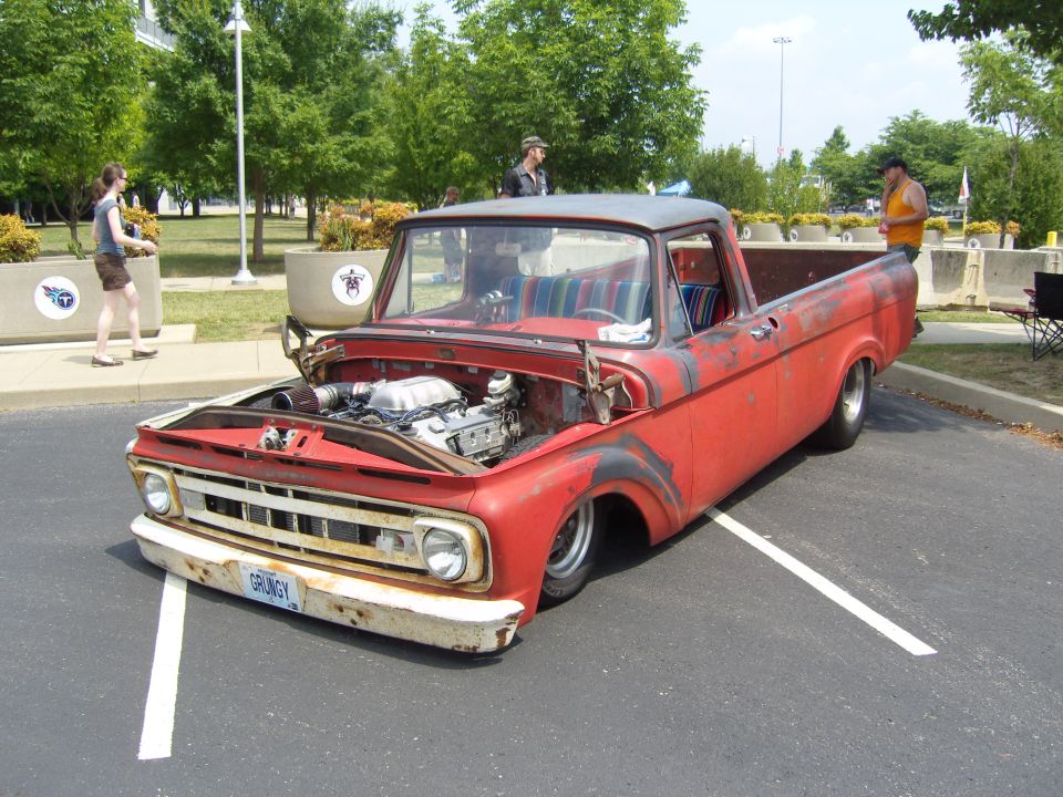 Red pickup truck with open hood, showing engine and custom interior