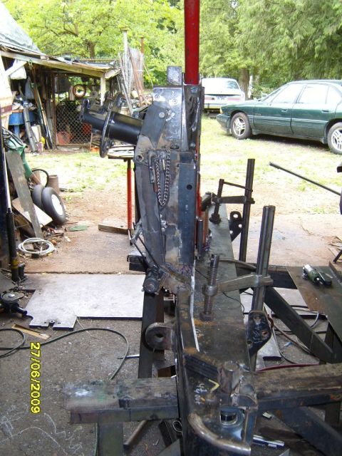 1989 Ford Bronco - Workshop scene with metal fabrication equipment and a green sedan in the background.