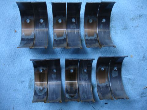 1993 Ford Taurus - Set of engine bearings showing signs of wear and heat damage, indicating potential engine issues.
