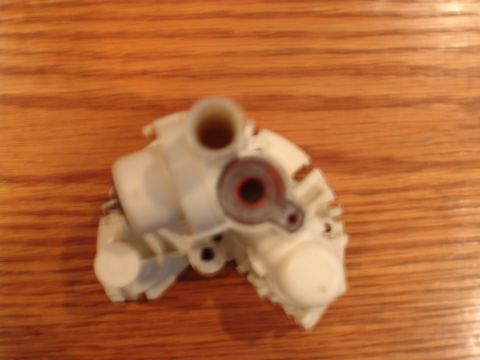 1996 Ford Bronco - A white plastic engine component, possibly for a Ford Bronco, is shown against a wooden background.