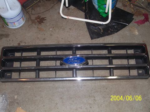 1990 Ford Bronco - A Ford grille with a blue oval emblem is shown against a concrete floor.