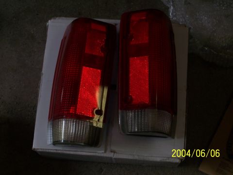 1990 Ford Bronco - Two red taillights are displayed on a white box, with a date stamp and website visible in the lower right corner.