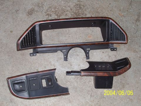 1990 Ford Bronco - Dashboard trim pieces from a vehicle, including the main instrument cluster bezel and lower switch panel.