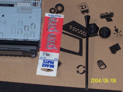 1990 Ford Bronco - Car stereo and brake parts are laid out on a cardboard surface.