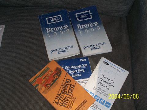 1990 Ford Bronco - A collection of Ford vehicle manuals, including two for the 1989 Bronco, a 1989 F-Series Super Duty manual, and a warranty booklet.
