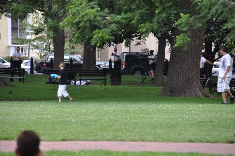 1996 Ford Bronco - People and vehicles are visible in a park setting with trees and grass.