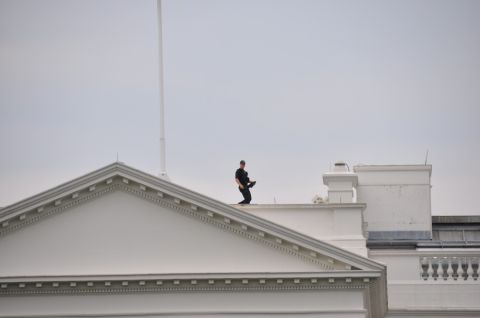 1996 Ford Bronco - A person is visible on the roof of a large white building under an overcast sky.