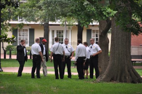 1996 Ford Bronco - Several men, some in uniform, stand in a grassy area near a large tree and a building.