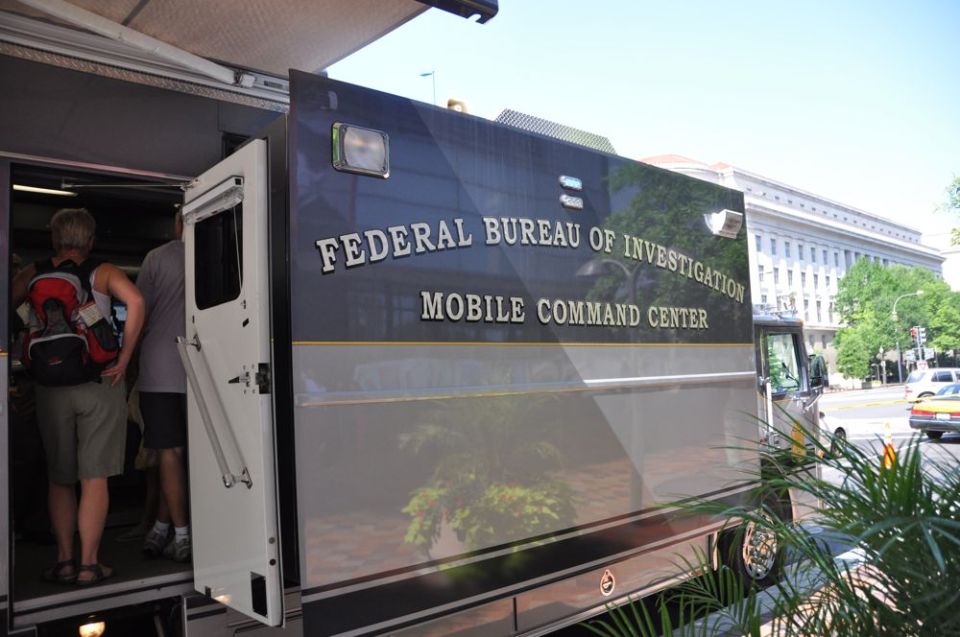 FBI Mobile Command Center truck parked outside a building, with people entering