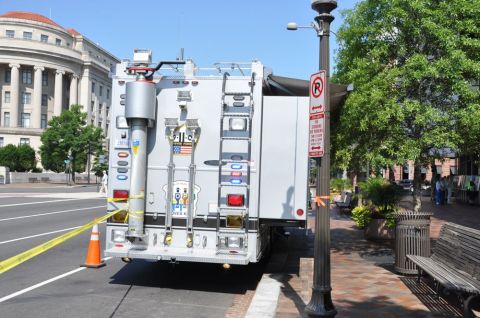 1996 Ford Bronco - Specialized truck with emergency equipment parked on a street with a building in the background.