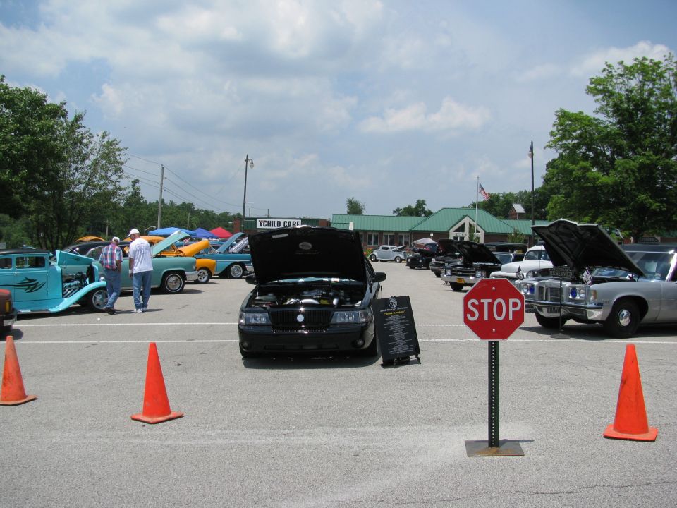 Black 2003 Mercury Marauder with hood open at a car show. Other cars are parked around