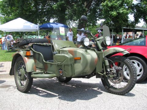 2003 Mercury Marauder - A military-style motorcycle with a sidecar is parked at an outdoor event next to a red sports car.