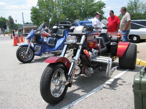 2003 Mercury Marauder - Two custom trike motorcycles are parked side-by-side at an outdoor event.