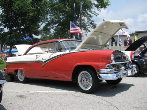 2003 Mercury Marauder - A classic red and white Ford Fairlane Crown Victoria is displayed with its hood up at an outdoor event.