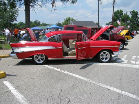 2003 Mercury Marauder - A red 1957 Chevrolet Bel Air is parked at an outdoor car show with its doors and hood open.