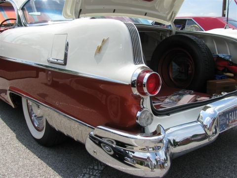 2003 Mercury Marauder - 1955 Pontiac Star Chief's rear end and open trunk with spare tire visible.