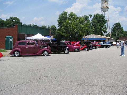 2003 Mercury Marauder - A car show multiple vintage vehicles parked in a lot under a bright sky.