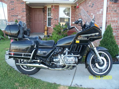 1982 Honda GL1100I GW Interstate - This Honda Gold Wing motorcycle is parked on a concrete driveway in front of a residential home.