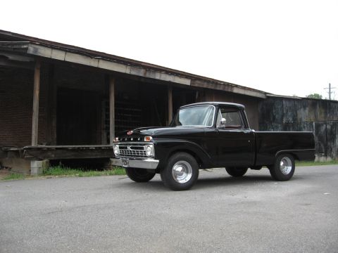 1966 Ford F-100 - 1966 Ford F-100 pickup truck with a black finish parked on asphalt.