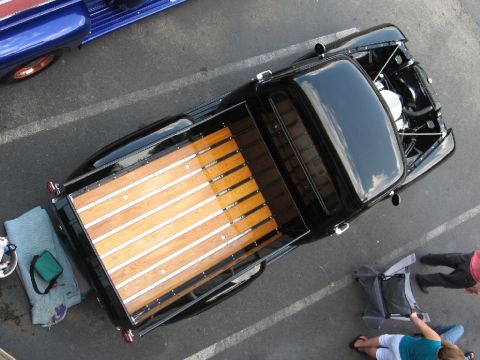 1966 Ford F-100 - Overhead view of a black pickup truck with a wooden bed, parked next to another vehicle.