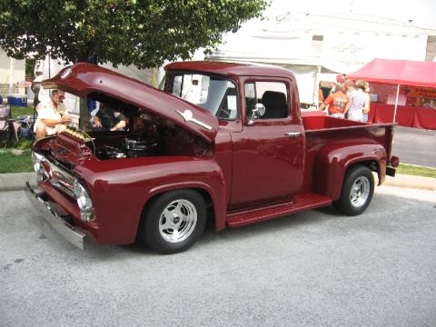 1966 Ford F-100 - A classic maroon pickup truck is displayed with its hood open, revealing the engine bay.