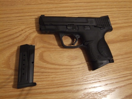 2002 Jeep TJ - A black semi-automatic pistol with its magazine rests on a wooden surface.
