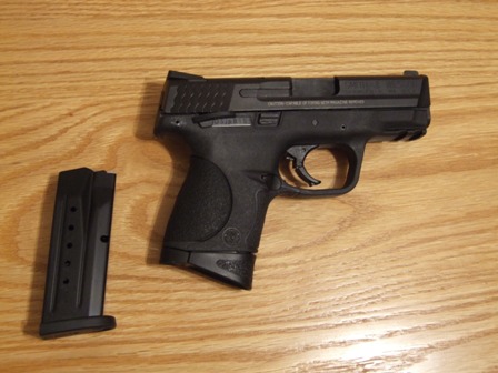 2002 Jeep TJ - A semi-automatic pistol and its magazine are displayed on a wooden surface.