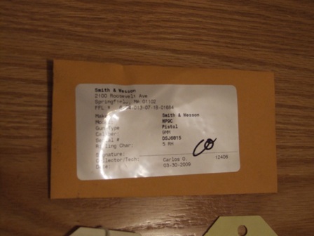 2002 Jeep TJ - A document detailing a Smith & Wesson pistol is shown on a wooden surface.