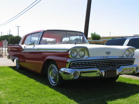 1984 Ford Bronco - A classic two-tone red and white 1959 Ford Fairlane 500 Skyliner is parked on a grassy lawn.