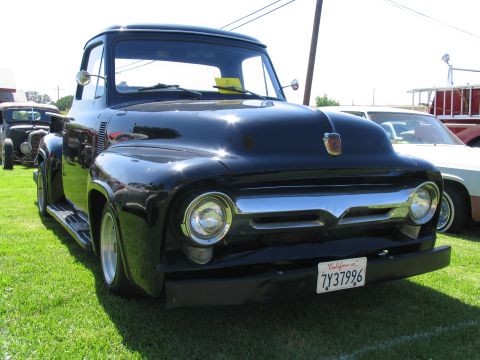 1984 Ford Bronco - Front view of a black 1953 Ford F-100 pickup truck at an outdoor car show.