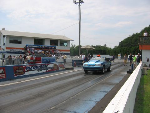 1992 Ford Mustang - A blue convertible drag car speeds down the track at Piedmont Dragway.