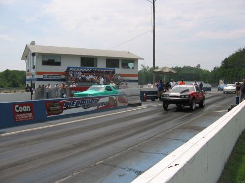 1992 Ford Mustang - A 1992 Ford Mustang competes in a drag race, showing its front profile on the track.