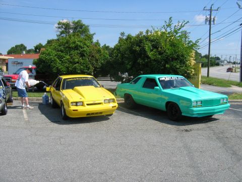 1992 Ford Mustang - A yellow 1987 Ford Mustang is parked next to a teal car in a parking lot.