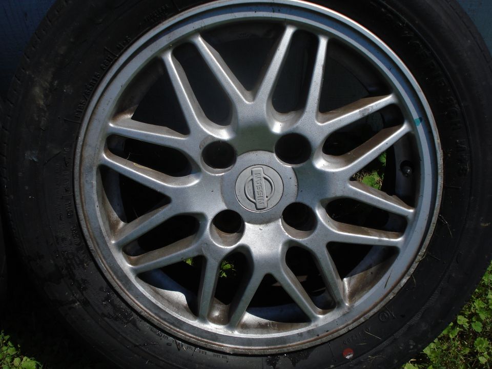 Close-up of a Nissan wheel with a multi-spoke design and the Nissan logo in the center