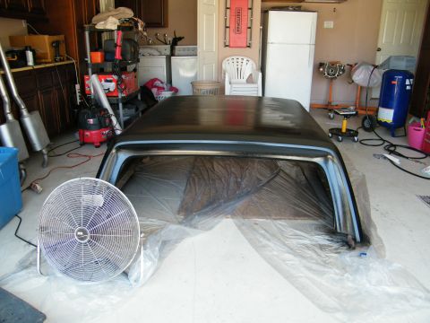 1982 Ford Bronco - A car hardtop is being prepped for painting in a garage, with a fan to aid drying.