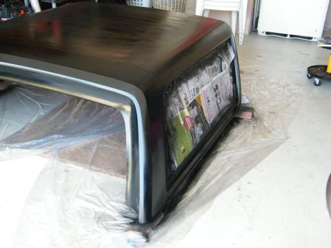 1982 Ford Bronco - A vehicle hardtop is covered in plastic and newspaper, likely for protection during a painting project.