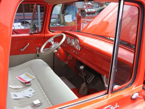 1966 Ford F-100 - Interior view of an orange truck, showing the dashboard, steering wheel, and seats.