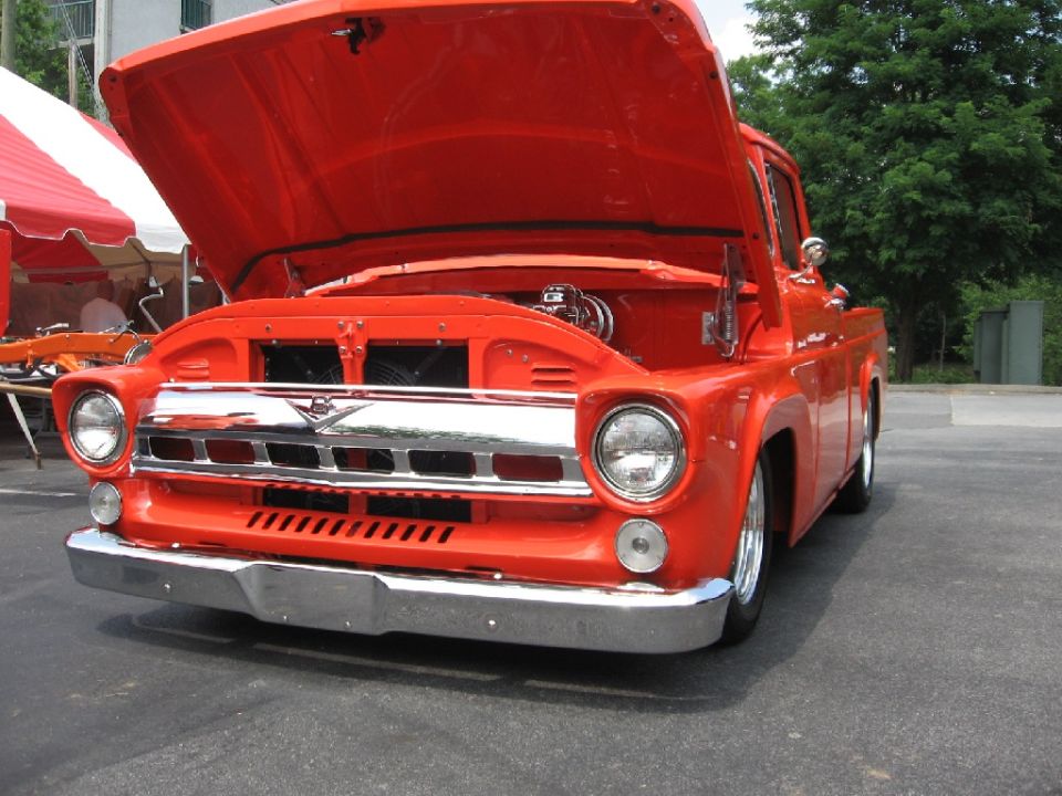 Orange 1956 Ford F-100 pickup truck, front view, hood open