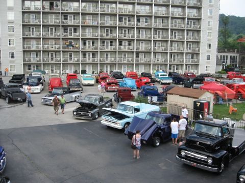 1966 Ford F-100 - A collection of classic pickup trucks, including a 1966 Ford F-100, are gathered in a hotel parking lot.