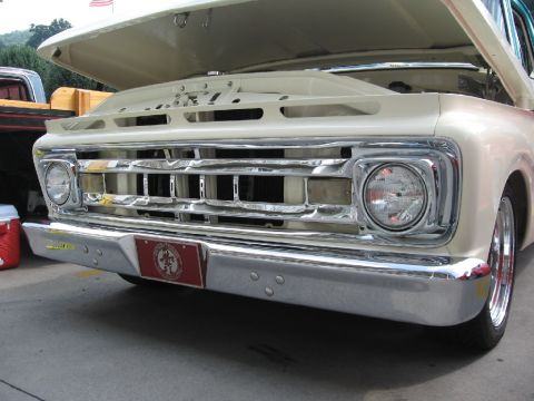 1966 Ford F-100 - Close-up of a 1965 Ford F-100 truck's front end, showing the grille and bumper.