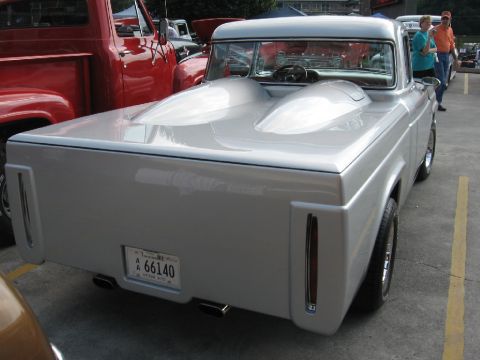 1966 Ford F-100 - Customized pickup truck with unique bed design and dual exhaust pipes visible.