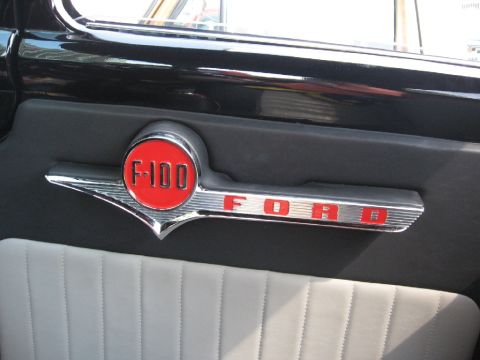 1966 Ford F-100 - Close-up of the F-100 emblem and Ford script on the door panel of a 1966 Ford F-100.