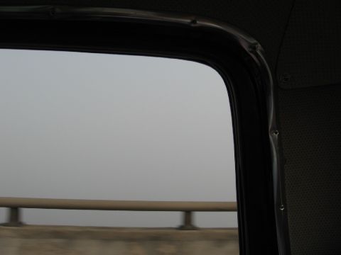 1966 Ford F-100 - A hazy view from inside a vehicle, showing a guardrail and a foggy landscape outside the window.