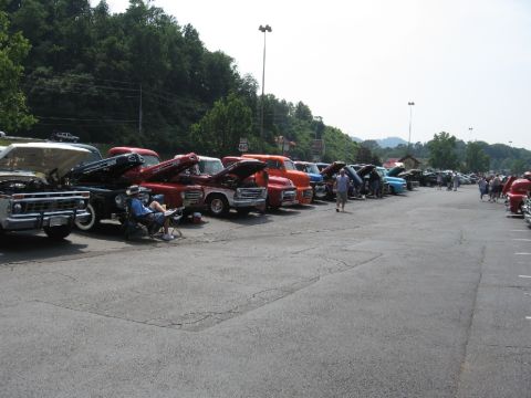 1966 Ford F-100 - A gathering of vintage pickup trucks displayed in a parking lot on a sunny day.