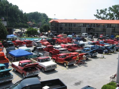 1966 Ford F-100 - A gathering of classic Ford F-100 trucks is parked in a lot, with a motel in the background.